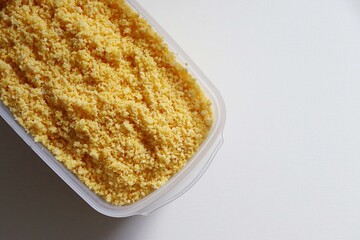 Flaked, pre-cooked flour for brazilian couscous. Moistened couscous mixture. Cuscuz brasileiro.
 