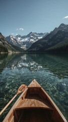 Obraz premium Canoe journey on a serene mountain lake with crystal clear water and majestic snow capped peaks under a clear blue sky