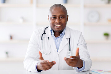 African american doctor sitting at workdesk at clinic, having appointments, giving recommendations....