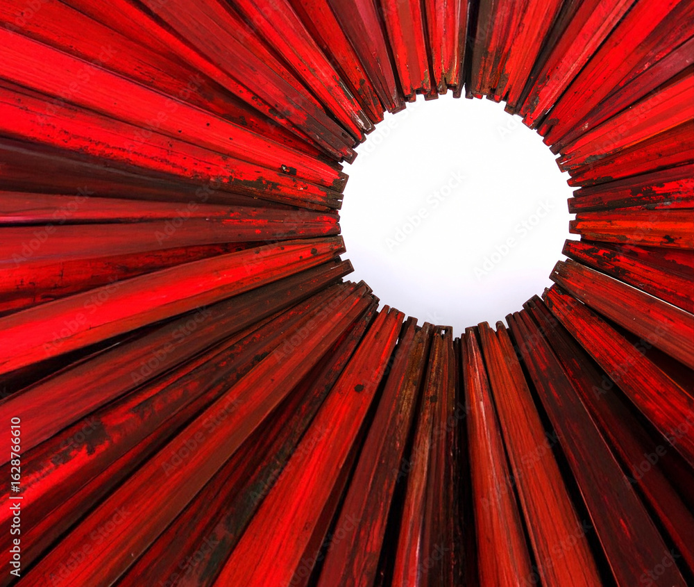 Poster a striking abstract close-up of distressed red wood sticks arranged in a radial pattern around a whi