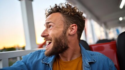 Young man with curly hair and beard, joyfully enjoying a ride at an amusement park, with vibrant sunset in the background, capturing the thrill of the moment and excitement of the experience