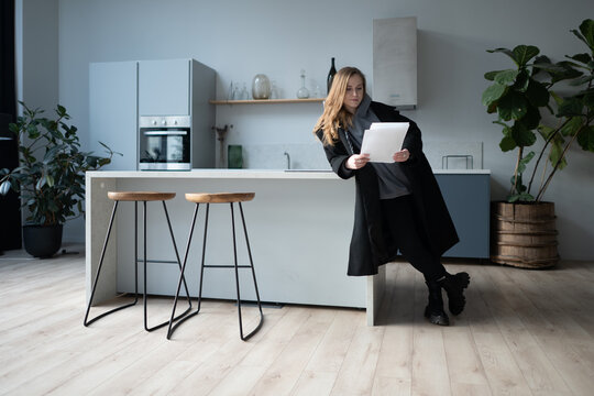Confident woman arriving at a modern apartment with luggage, potentially a tenant or property owner reviewing new real estate.