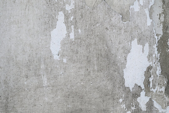 Rough texture of old concrete or plastered wall with fragments of peeling white paint. Ideal for creating grunge effects, vintage backgrounds.