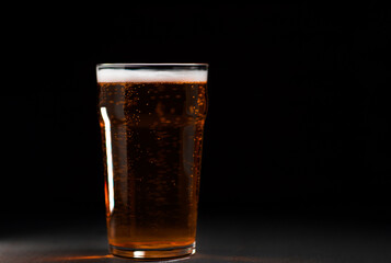 Beer glass on black background copy space
