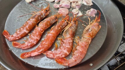 Traditional spanish seafood paella with shrimp and ingredients in large pan. Typical cuisine of...