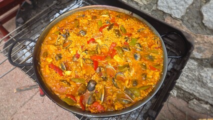 Delicious traditional spanish paella with seafood and vegetables. Typical cuisine of Spain. Valencian cuisine. Stage of cooking paella. Ingredients for paella