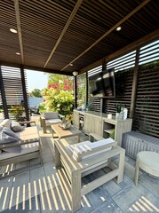 Modern indoor outdoor living entertainment space and patio under a pavilion pergola. poolside...