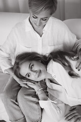 Mother embracing daughter lying on her legs, showing love and tenderness