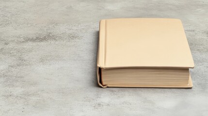 Fototapeta premium Beige Book on Textured Gray Surface, Reading , Literature