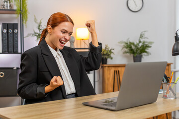 Young businesswoman at home office opens laptop sees approval for project breathes deep joy....