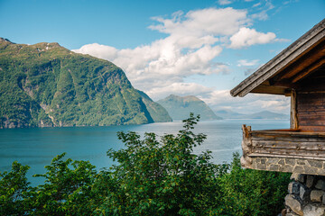 Scenic View of Serene Norwegian Fjord with Rustic Cabin Overlooking Majestic Mountains and Pristine...