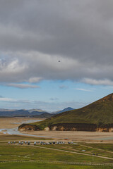 Rugged Icelandic Mountain with River and Parked Vehicles