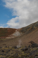 Geothermal Landscape with Steaming Fumarole and Distant Figure in Iceland