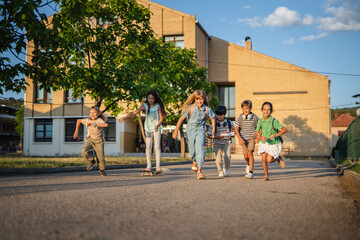 Obraz premium Group of elementary school students running and skateboarding after school