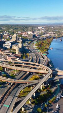 Traffic on the overpasses on the banks of the Hudson River. Aerial view of the Interstate 787 and South Mall Arterial interchange in downtown Albany. Vertical video.