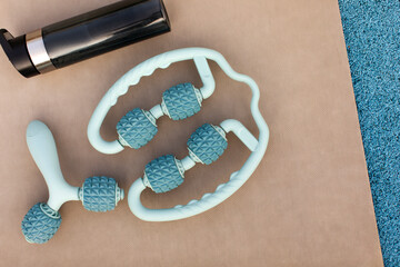 Two anti-cellulite manual plastic massager with silicone rollers with pimples and water bottle on...