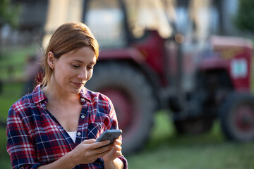 Female farmer using phone outdoors early in morning