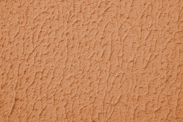 Close up of textured orange color painted wall with rough stucco, plaster wall texture. Vibrant...