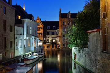 Historic canal at dusk with moored boats in Bruges
