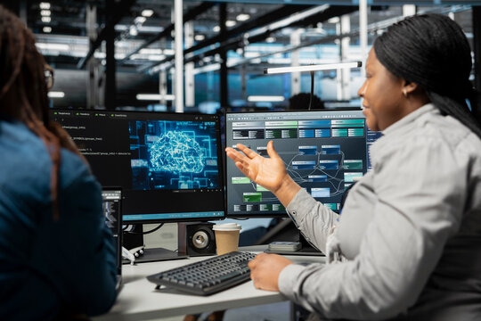Data center engineering team talking in office, using artificial intelligence computerized model. Teamworking server room colleagues working with AI machine learning algorithms