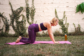 Mother engages in postnatal fitness in a tranquil outdoor setting