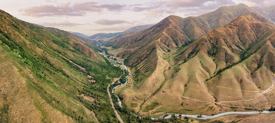 Stunning panoramic view of the mountain range with its colorful slopes and valley during golden...