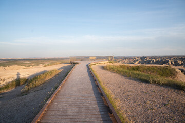 Wooden boardwalk trail at sunrise in Badlands National Park, South Dakota