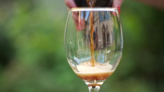 dark beer being poured into a glass
