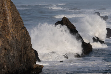Two splashes from a wave on the rocks