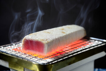 煙りの立ち昇る七輪で鮪の炙り