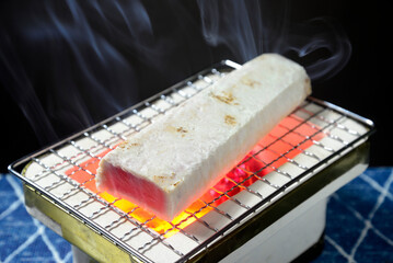 煙りの立ち昇る七輪で鮪の炙り