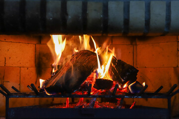 A close-up photograph depicts a fireplace with a vibrant fire burning. Logs are crackling amidst...