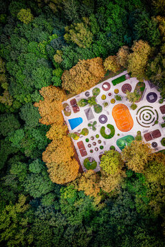 Aerial view of an enchanting garden with vibrant colors surrounded by a lush forest, a hidden gem of tranquility, Poland.