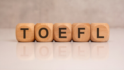 TOEFL word formed with wooden cubes on glossy surface, symbolizing English language exam