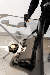 Technician scrapes and cleans new windshield after replacement to ensure perfect adhesion....