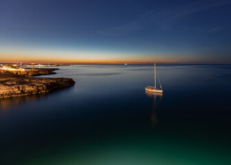 Sailboat anchored at sunset on a calm sea.
Long exposure image.