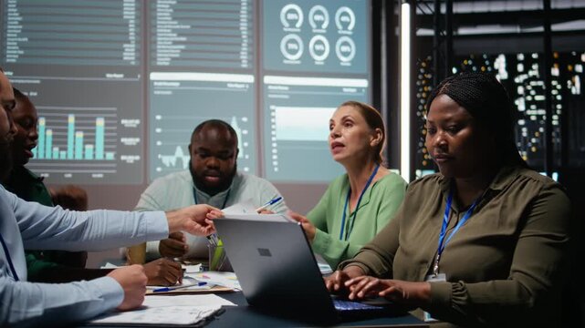 Portrait of african american advisor uses laptop in a night meeting to review updates, building a business strategy and establishing clear objectives. Woman corporate administrator. Camera A.