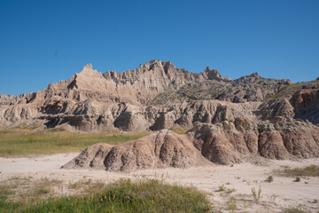 Eroded rock formations under blue sky in Badlands National Park, South Dakota