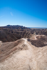 Layered rock formations under clear sky in Badlands National Park, South Dakota