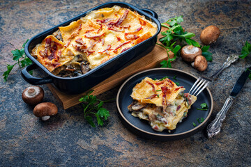 Artisan homemade traditional vincisgrassi marche pasta with mushrooms, prosciutto and bechamel cream oveb baked served as close-up in classic casserole
