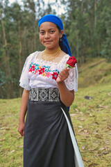 Indigenous otavalo woman holding red rose in ecuadorian andes mountains