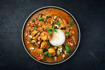 Traditional Thai red curry with king prawns and vegetable - kaeng phet as top view in a bowl with...