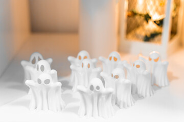 A group of small white ghost figurines arranged in rows, perfect for Halloween decorations. Spooky...