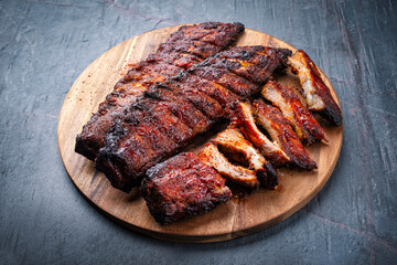Barbecue tandori masala pork spareribs St Louis cut with hot rub served as close-up on a wooden cutting board