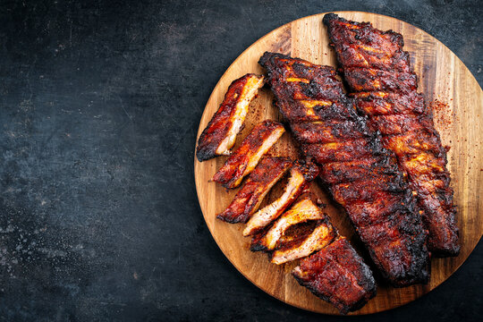 Barbecue tandori masala pork spareribs St Louis cut with hot rub served as top view on a wooden cutting board