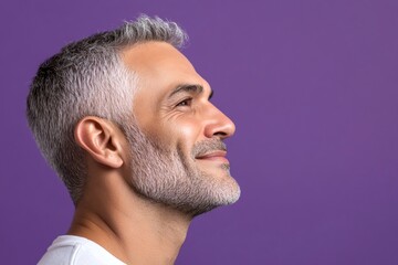 Obraz premium Creative pattern of style for aging men. A soft and natural man with a glowing expression. Chic men's two-block cut haircut - midlife arabian man with short hair. Purple solid background.