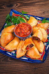 Artisan Argentinian homemade empanadas with minced meat and salsa dip served as close-up on a...