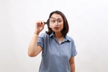 Fototapeta premium Surprised funny asian woman searching for something, found product, looking through magnifying glass amazed and impressed. Small business owners, women entrepreneurs concept.