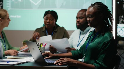 Diverse administrative team attending briefing conference at night to verify updates on regulatory changes or industry standards. Business professionals reviewing all data analysis. Camera B. - Powered by Adobe