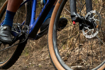 A close-up of a mountain bike in action on rough terrain. The gears and suspension are captured with great clarity, conveying strength, endurance, and adrenaline.